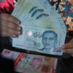 petugas-menjunjukkan-mata-uang-dolar-singapura-dan-rupiah-di-vip-money-changer-jakarta-kamis-2592025-1758795008466_169